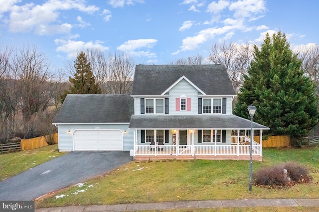 view of front of home featuring a porch, a garage, and a front lawn