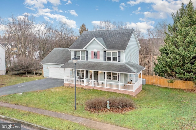 view of front of property featuring a garage, covered porch, and a front lawn