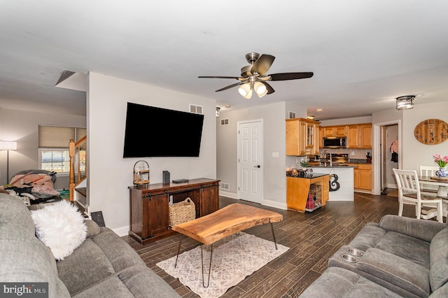 living room with ceiling fan and dark hardwood / wood-style flooring