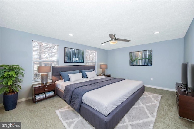 carpeted bedroom with ceiling fan and a textured ceiling