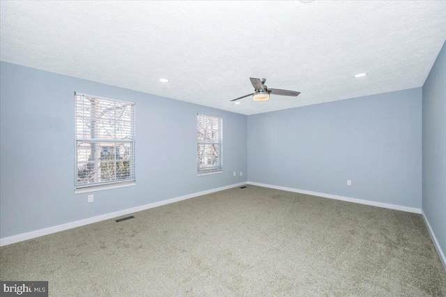 spare room with ceiling fan, carpet, and a textured ceiling