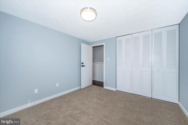 unfurnished bedroom with a closet, carpet, and a textured ceiling