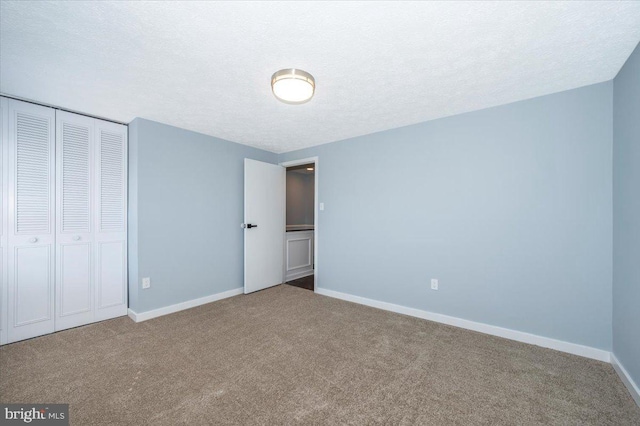 unfurnished bedroom featuring a closet, a textured ceiling, and carpet flooring