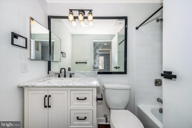 full bathroom featuring tiled shower / bath combo, vanity, and toilet