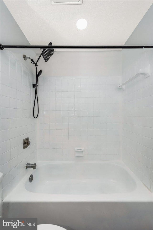 bathroom featuring tiled shower / bath and toilet