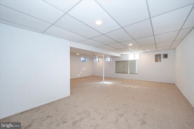 basement featuring carpet and a drop ceiling