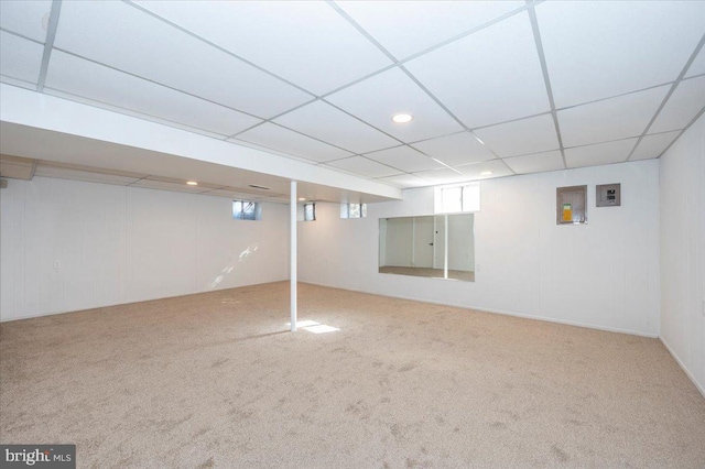 basement with a drop ceiling and carpet