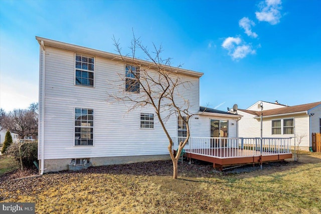 rear view of property with a yard and a deck