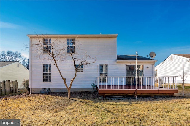 rear view of house with a wooden deck and a yard