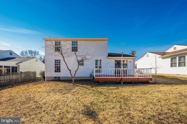 rear view of house featuring a wooden deck and a yard