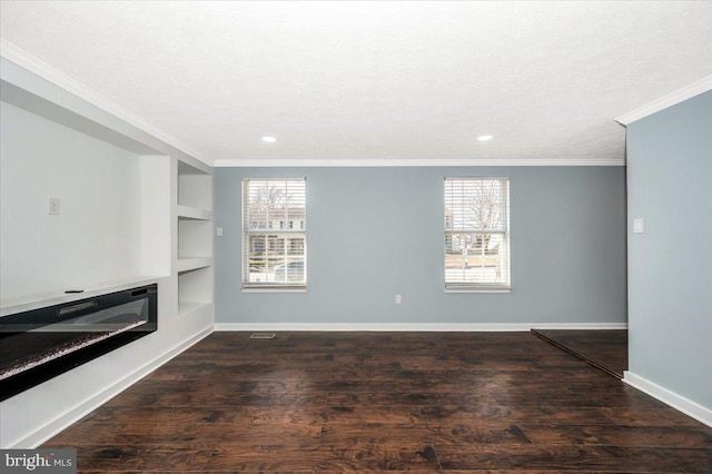 unfurnished living room featuring crown molding, built in shelves, dark hardwood / wood-style floors, and a healthy amount of sunlight