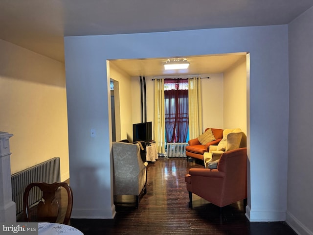 living room with radiator and dark wood-type flooring