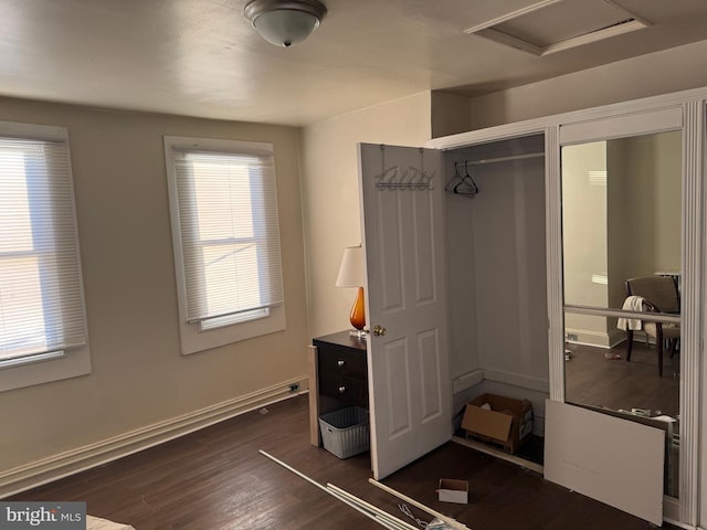 bedroom with multiple windows and dark hardwood / wood-style floors