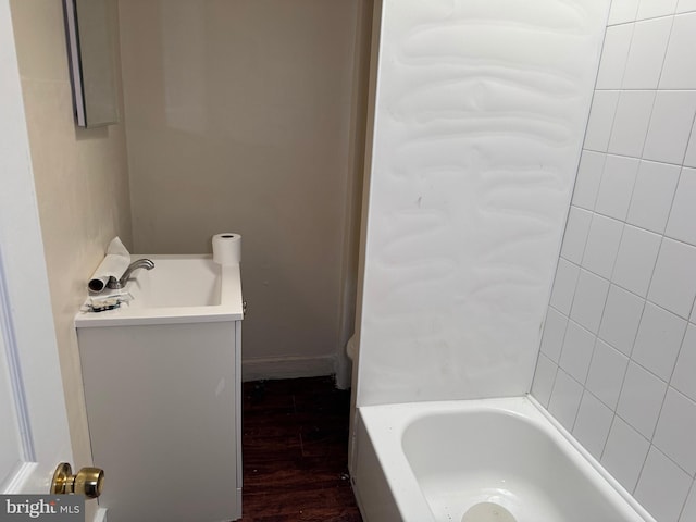 bathroom featuring hardwood / wood-style flooring, vanity, and a tub to relax in