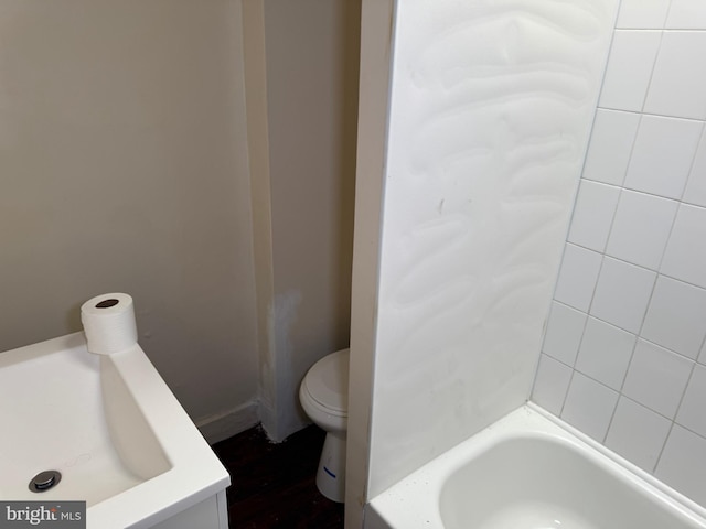 bathroom with a tub to relax in and toilet