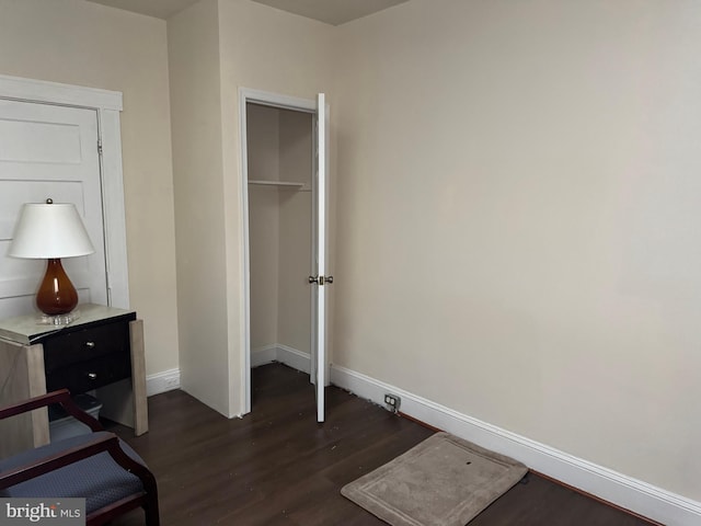 bedroom with dark wood-type flooring and a closet