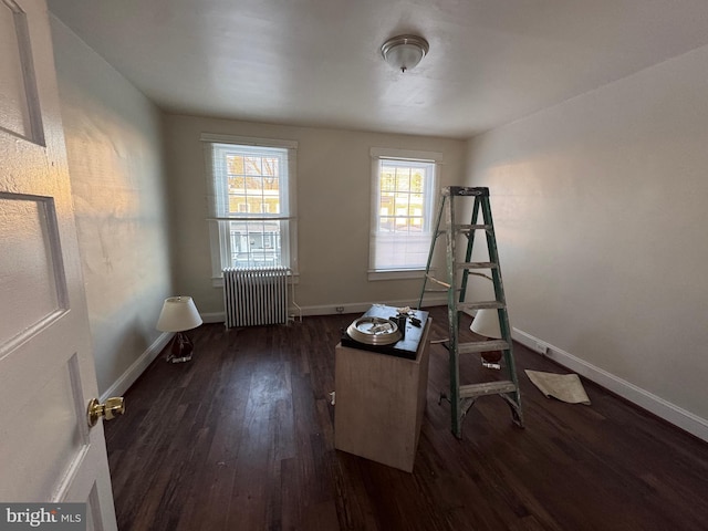 interior space with radiator heating unit and dark hardwood / wood-style flooring