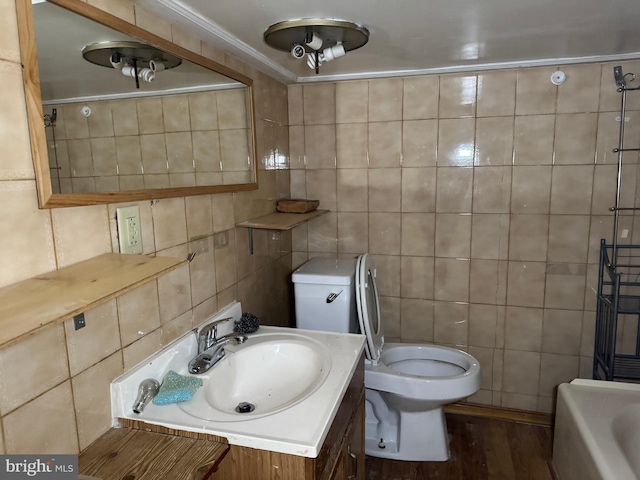 bathroom with hardwood / wood-style flooring, tile walls, vanity, a tub, and toilet