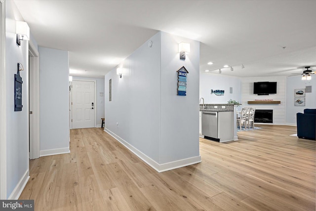 corridor with sink and light hardwood / wood-style flooring