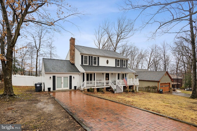 view of front of house featuring a garage, covered porch, and french doors