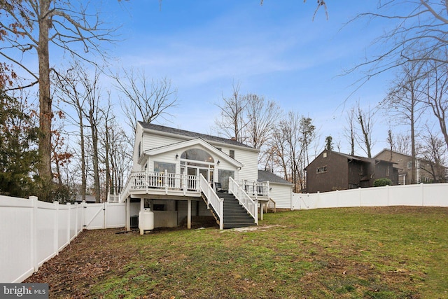 rear view of property with a deck and a lawn