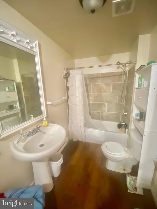 bathroom with shower / tub combo, hardwood / wood-style floors, and toilet