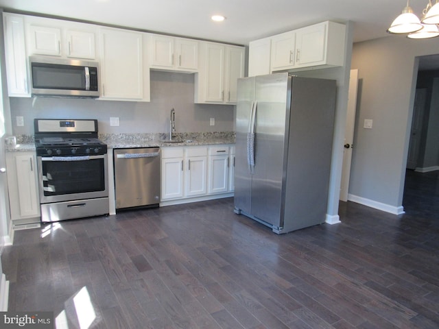 kitchen featuring sink, dark wood-type flooring, stainless steel appliances, white cabinets, and decorative light fixtures