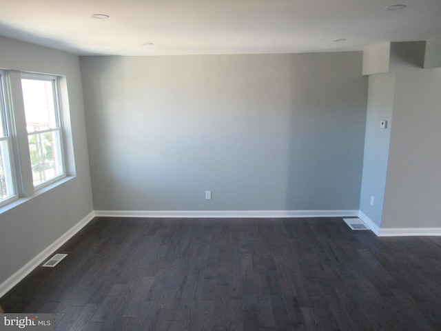 empty room with dark hardwood / wood-style flooring