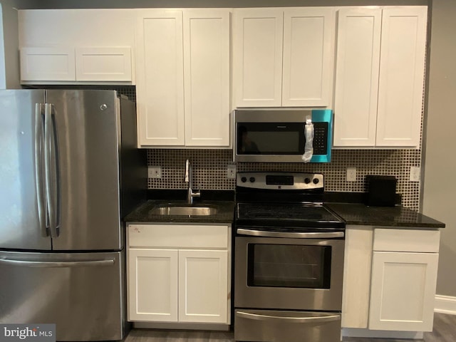 kitchen with stainless steel appliances, tasteful backsplash, sink, and white cabinets