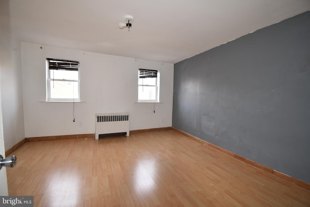 unfurnished room featuring radiator and light hardwood / wood-style floors