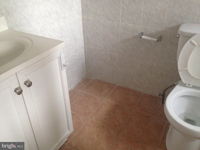 bathroom featuring vanity, tile patterned floors, tile walls, and toilet