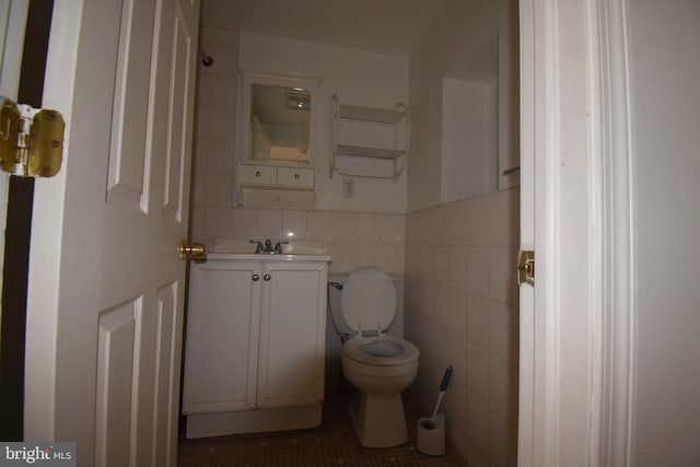 bathroom featuring tile walls, vanity, tile patterned flooring, and toilet