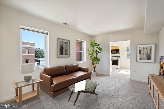 living room with baseboards, visible vents, and light colored carpet