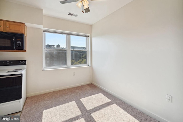 kitchen with black microwave, carpet flooring, visible vents, white range with electric stovetop, and brown cabinetry