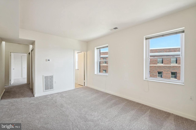 unfurnished room featuring light carpet, baseboards, and visible vents