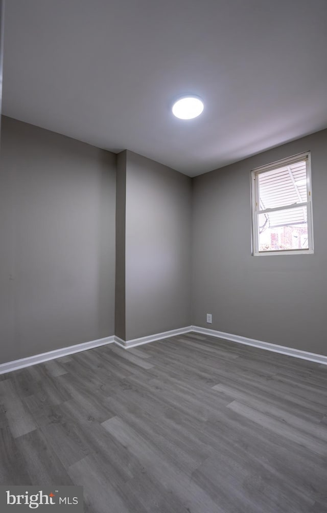 unfurnished room with dark hardwood / wood-style flooring