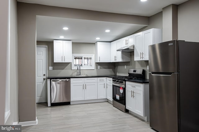 kitchen with appliances with stainless steel finishes, sink, light hardwood / wood-style flooring, and white cabinets