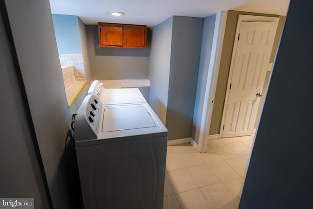 clothes washing area featuring light tile patterned flooring and separate washer and dryer