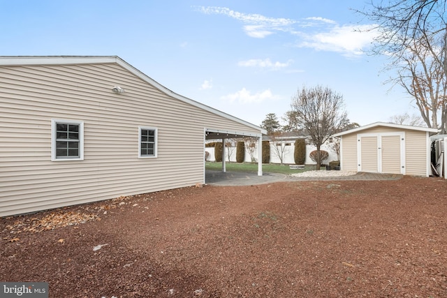 view of side of home with a carport and a shed