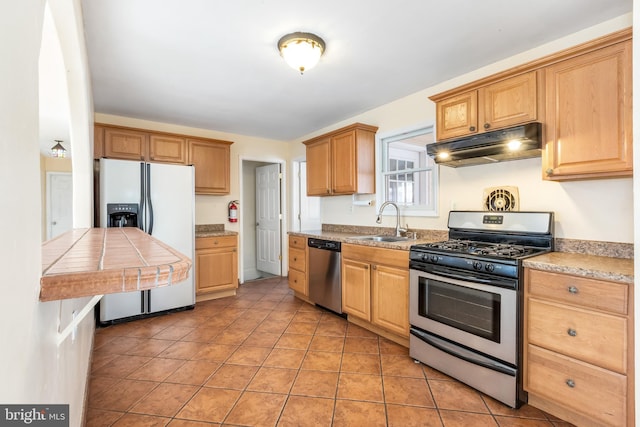 kitchen featuring stainless steel appliances, sink, and light tile patterned floors