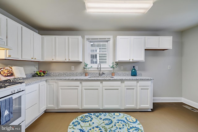 kitchen with sink, white cabinets, and white range with gas stovetop