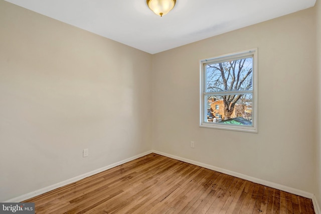 empty room featuring baseboards and hardwood / wood-style floors