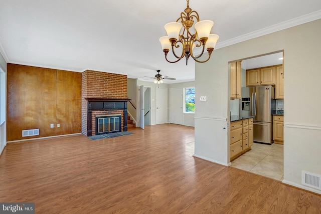 unfurnished living room featuring ornamental molding, a fireplace, visible vents, and light wood-style floors