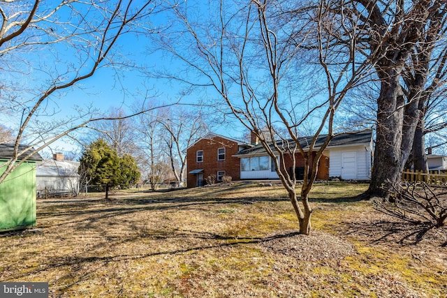 view of side of property with brick siding and fence