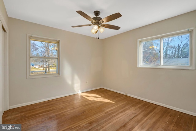 unfurnished bedroom with a ceiling fan, a closet, baseboards, and hardwood / wood-style flooring