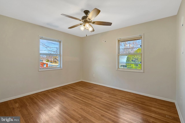 empty room with wood-type flooring, ceiling fan, and baseboards