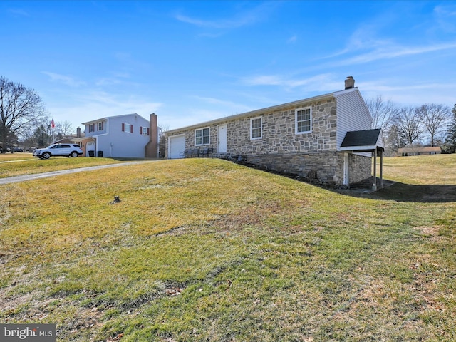 view of front of home with a garage, stone siding, a chimney, and a front lawn