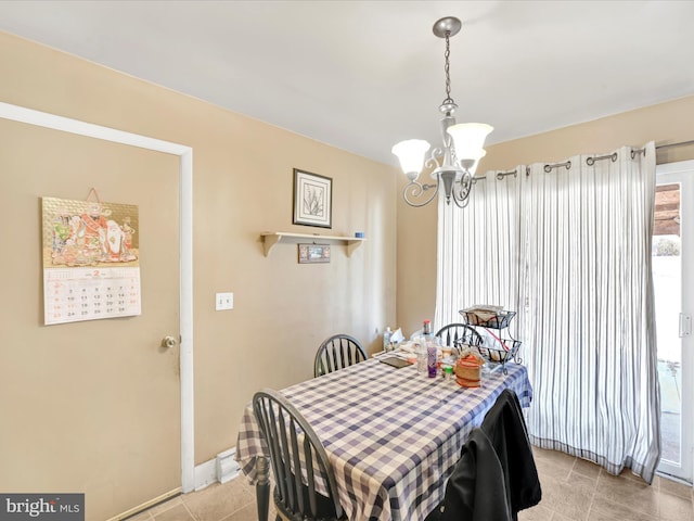 dining room featuring baseboards, a notable chandelier, and light tile patterned flooring