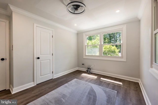 spare room with ornamental molding and dark hardwood / wood-style flooring