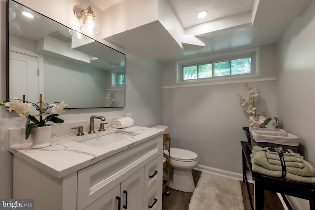 bathroom featuring hardwood / wood-style flooring, vanity, and toilet